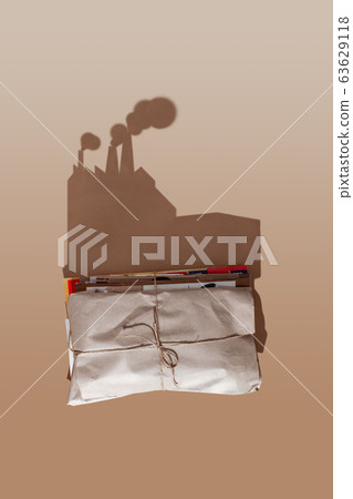 A stack of waste paper casts a hard shadow in the form of a garbage recycling plant. A stack of waste paper casts a hard shadow in the form of a garbage recycling plant. 63629118