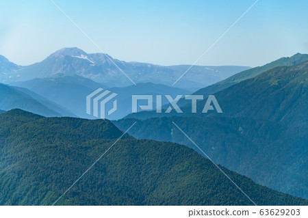 High mountains with green slopes and snowy peaks. 63629203