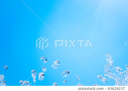 Splashes of water against the blue sky background 63629237