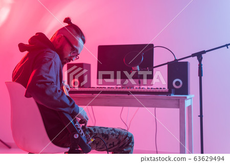 Musician and making music concept - Male sound producer working in recording studio. Musician and making music concept - Male sound producer working in recording studio. 63629494