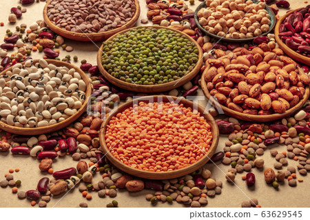 Legumes assortment on a brown background. Lentils, soybeans, chickpeas, red kidney beans, a vatiety of pulses Legumes assortment on a brown background. Lentils, soybeans, chickpeas, red kidney beans, a vatiety of pulses 63629545