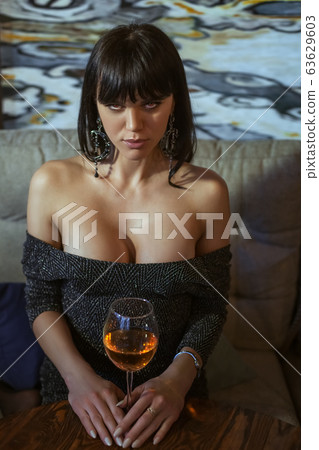 Sexy young woman holding a glass of wine. Sexy young woman holding a glass of wine. 63629603