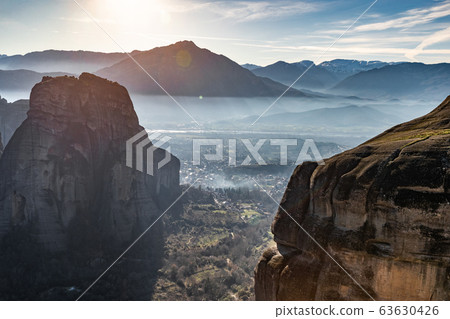 Aerial view of Unesco monument Meteora, the mountains, the landmark of Greek, sunny weather, fog, haze over a valley Aerial view of Unesco monument Meteora, the mountains, the landmark of Greek, sunny weather, fog, haze over a valley 63630426