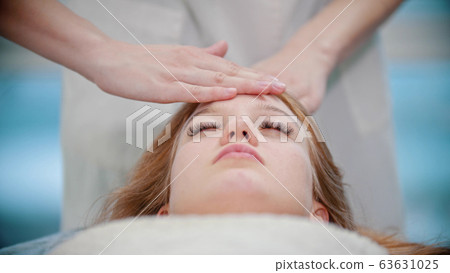 Massage - masseuse is kneading her clients face with her palms 63631025