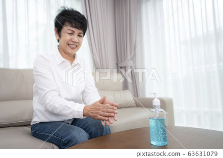 Asian old people use alcohol gel for cleaning her 63631079
