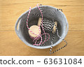 Pink and black striped string in gray basket 63631084