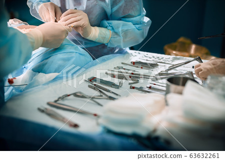 The surgeon's hands are holding an operating tool in the operating room. Close-up, beautiful light, modern medicine, Saving lives. 63632261