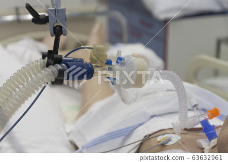 Respiratory connection tube, HME filter and suction catheter, patient connected to medical ventilator in ICU in hospital. Respiratory connection tube, HME filter and suction catheter, patient connected to medical ventilator in ICU in hospital. 63632961