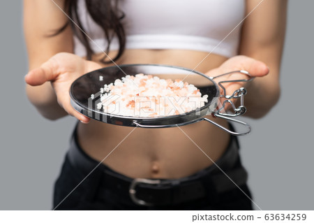 Girl in a white top holding a mirror in her hands Girl in a white top holding a mirror in her hands 63634259