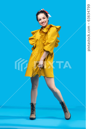Young woman in a mustard dress looking attractive 63634799