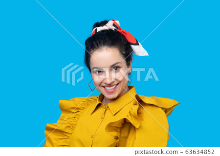 Young woman in a mustard dress looking flirty 63634852