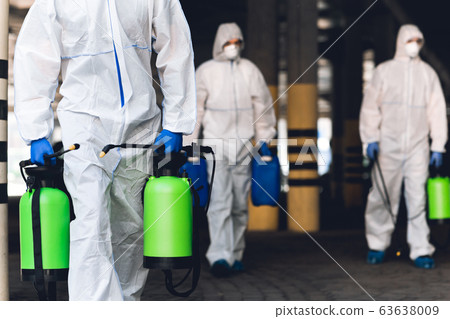 Men in virus protective suits carrying spray bottles with chemicals 63638009