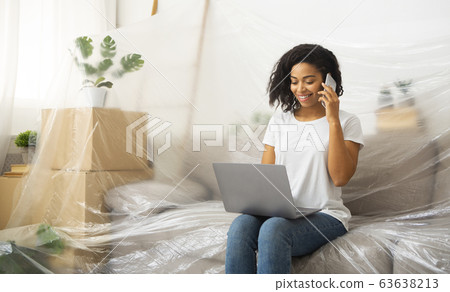 Girl with smartphone and laptop, sits on couch covered oilcloth 63638213
