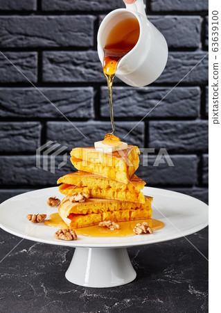 pouring honey on a stack of pancake pouring honey on a stack of pancake 63639100