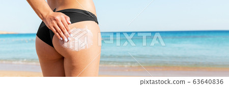 Woman hand is applying suntan cream on her 63640836