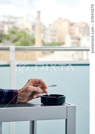 man in pajamas smoking in the balcony man in pajamas smoking in the balcony 63643879