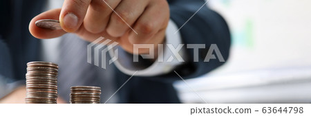 Male hands in suit stack coins on table, saving Male hands in suit stack coins on table, saving 63644798