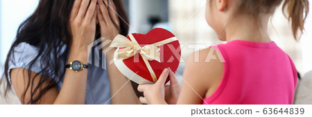 Cute little girl giving her mom birthday present Cute little girl giving her mom birthday present 63644839