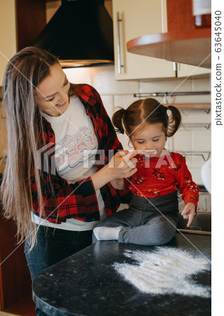 Social Distancing and Self-Isolation, stay home, quarantine, families self-isolating together for Novel Coronavirus COVID-19. Mom and toddler daughter play in the kitchen. Social Distancing and Self-Isolation, stay home, quarantine, families self-isolating together for Novel Coronavirus COVID-19. Mom and toddler daughter play in the kitchen. 63645040