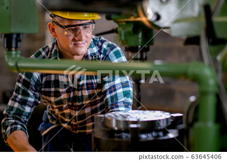 Technician or worker man work with the machine in factory with day light 63645406