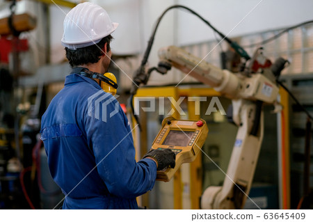 Back of blue uniform technician or worker man control and check the robot working Back of blue uniform technician or worker man control and check the robot working 63645409