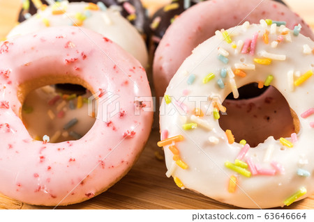 Donuts and coffee on wooden table. Donuts and coffee on wooden table. 63646664