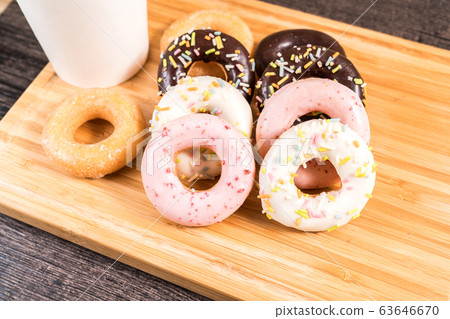 Donuts and coffee on wooden table. Donuts and coffee on wooden table. 63646670