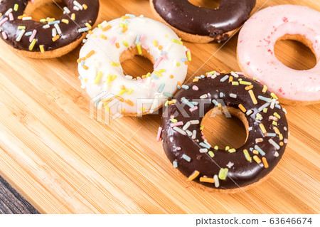 Donuts and coffee on wooden table. Donuts and coffee on wooden table. 63646674