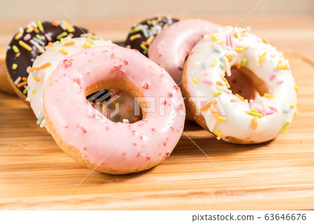 Donuts and coffee on wooden table. 63646676