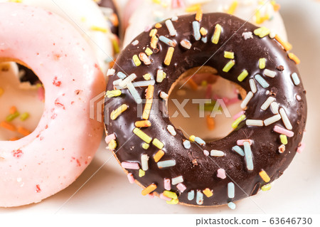 Donuts and coffee on wooden table. 63646730
