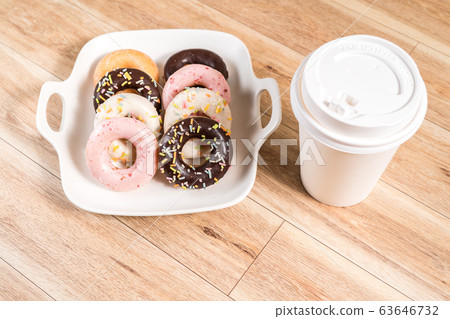 Donuts and coffee on wooden table. Donuts and coffee on wooden table. 63646732