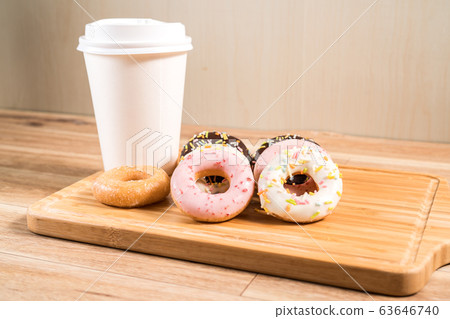Donuts and coffee on wooden table. Donuts and coffee on wooden table. 63646740