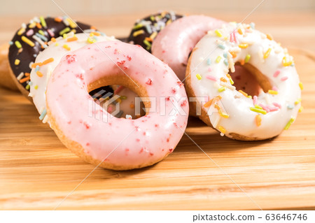 Donuts and coffee on wooden table. Donuts and coffee on wooden table. 63646746