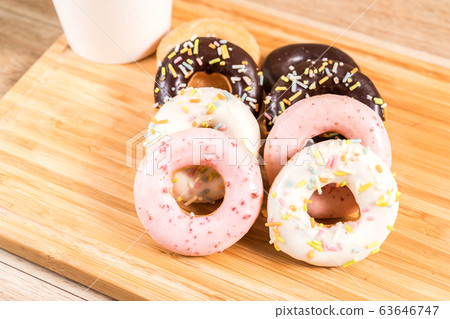Donuts and coffee on wooden table. Donuts and coffee on wooden table. 63646747