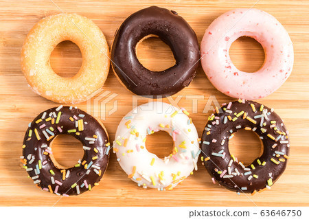 Donuts and coffee on wooden table. Donuts and coffee on wooden table. 63646750