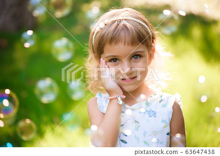 Llittle girl child with heterochromia two colored eyes outdoor in summer day. Llittle girl child with heterochromia two colored eyes outdoor in summer day. 63647438