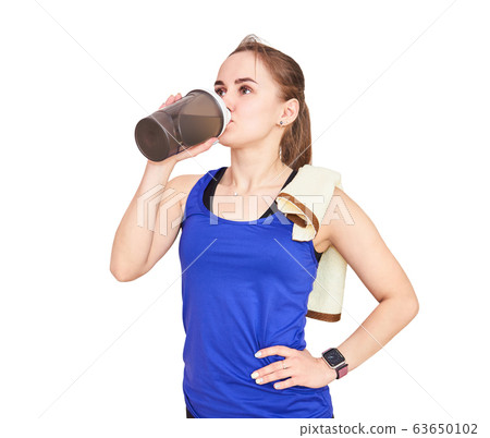 young athletic woman with a towel drinks from a 63650102