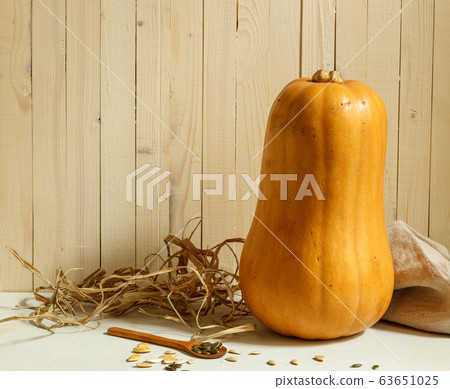 Lagenaria pumpkin , linen napkin and wooden spoon with seeds on a background of light boards, horizontal with space 63651025