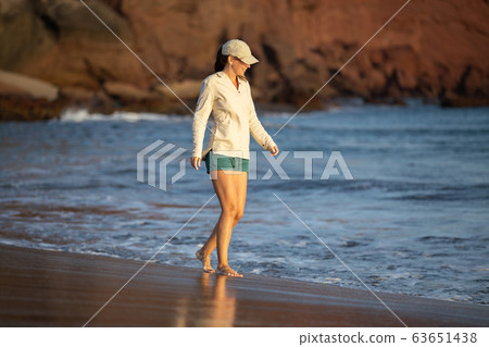 Young woman having fun at ocean beach on vacation Young woman having fun at ocean beach on vacation 63651438