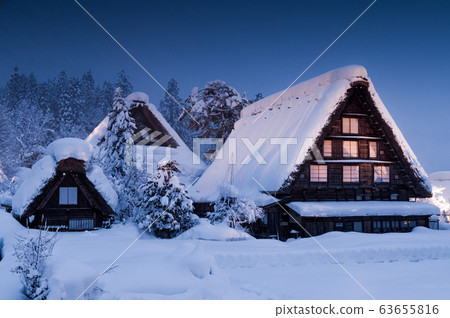 A vila de Shirakawa, um patrimônio mundial, com suas casas tradicionais com telhados em estilo gassho-zukuri a noite no inverno 63655816
