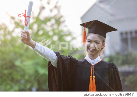 Women Student Graduate in cap and gown celebrating with certificate in hand and so proud Women Student Graduate in cap and gown celebrating with certificate in hand and so proud 63659947