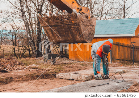A chain excavator pulls concrete slabs to set the A chain excavator pulls concrete slabs to set the 63661450