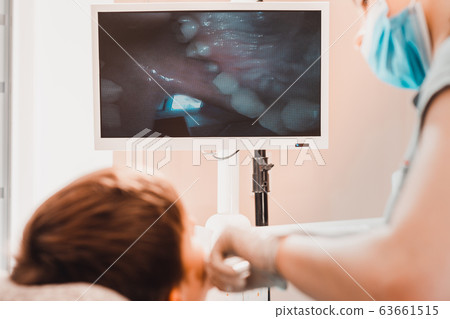 A young female dentist examines the teeth of a boy A young female dentist examines the teeth of a boy 63661515
