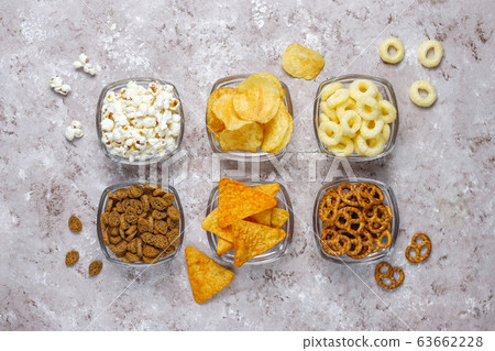 Salty snacks. Pretzels, chips, crackers,popcorn in bowls. Unhealthy products. food bad for figure, skin, heart and teeth. Assortment of fast carbohydrates food Salty snacks. Pretzels, chips, crackers,popcorn in bowls. Unhealthy products. food bad for figure, skin, heart and teeth. Assortment of fast carbohydrates food 63662228