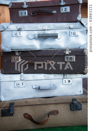 Vintage weathered leather and metal suitcases on top of each other. Retro. Background 63663151