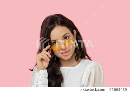 Young woman in a white shirt wearing eyeglasses Young woman in a white shirt wearing eyeglasses 63663489