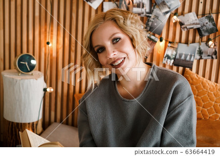 Woman relaxing and reading book on cozy bed 63664419