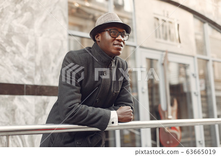 Black man in a black coat in a autumn city 63665019