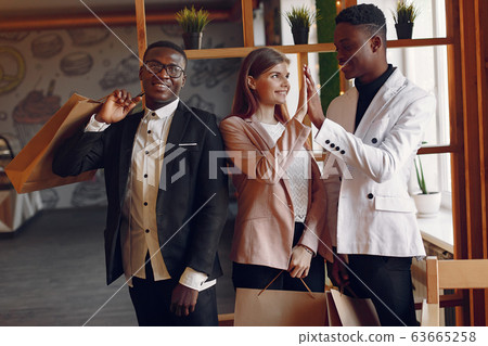 Internationals people standing in a cafe with shopping bags Internationals people standing in a cafe with shopping bags 63665258