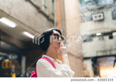 Asian woman traveling and smoking Asian woman traveling and smoking 63665334